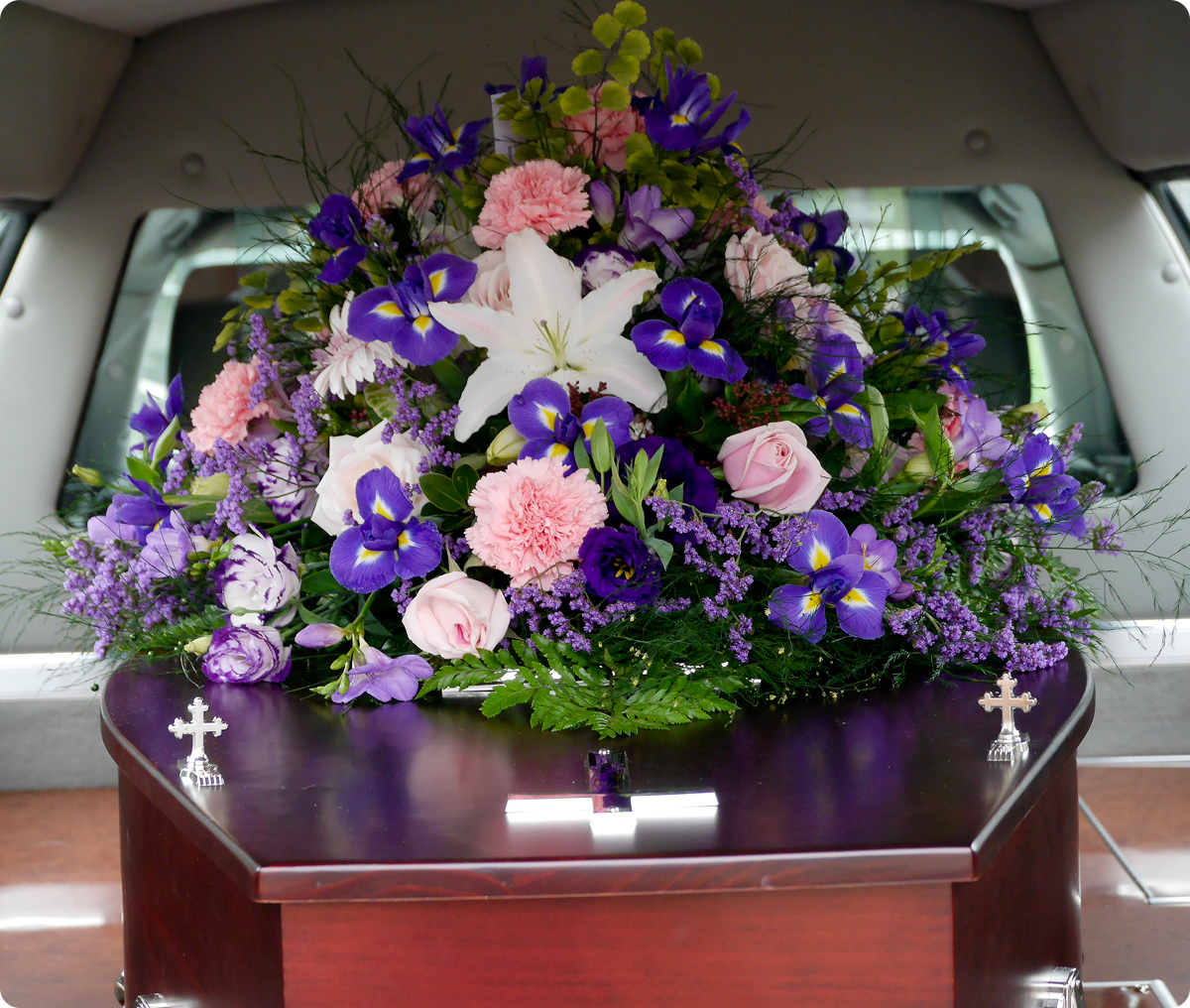 Casket adorned with colorful floral arrangement